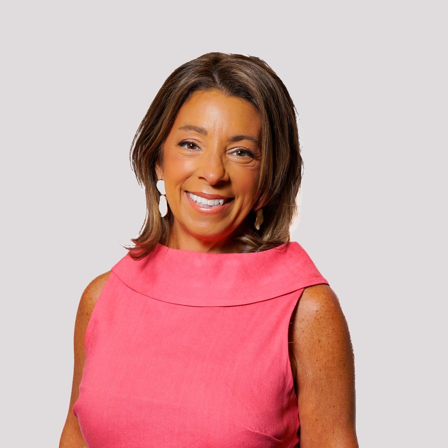 Lisa DeFalco smiling in a coral sleeveless top